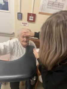 Studentky při líčení a česání seniorů.